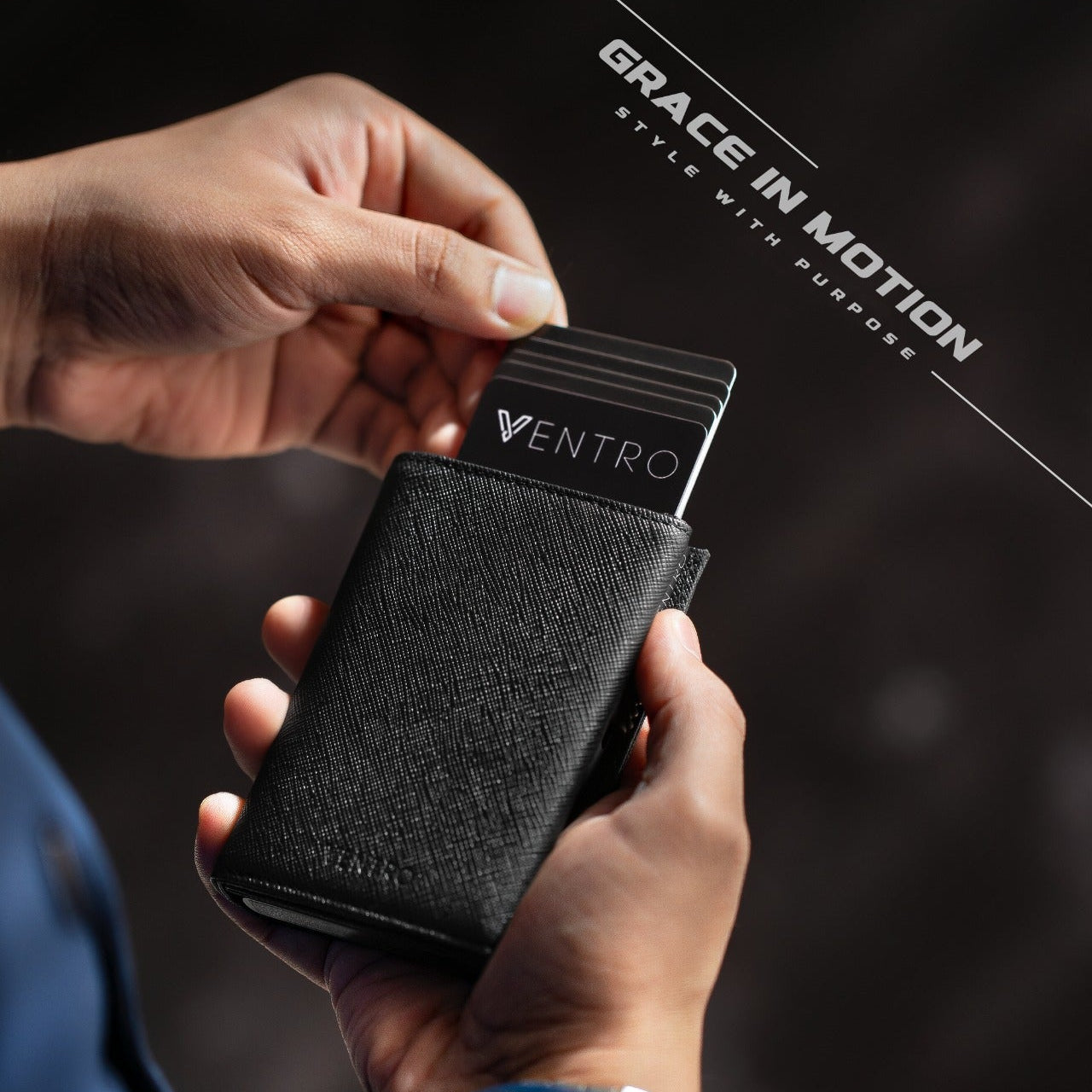 Person holding a black cardholder with cards, brand 'Ventro' visible, on a dark background with 'Grace in Motion' text. Saffiano black in hand ventro wallet with nfc