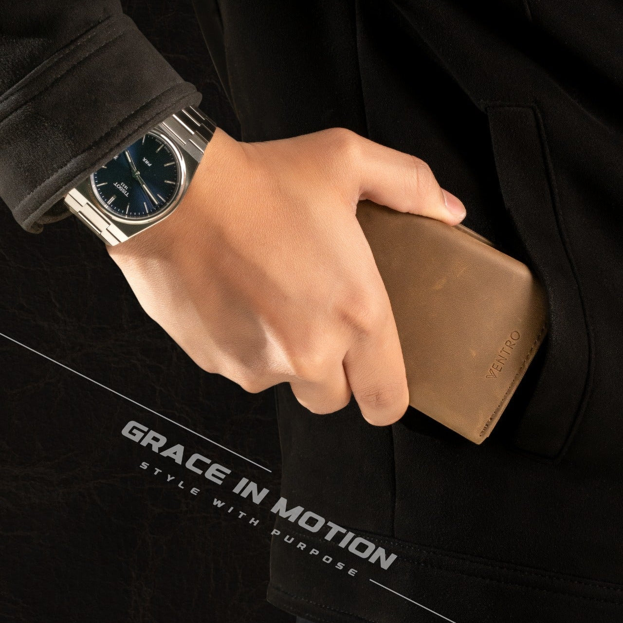 Hand holding a brown wallet with a black jacket and watch, featuring 'Grace in Motion' text.